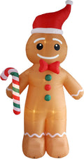 Giant inflatable gingerbread man in a Santa hat holding a candy cane