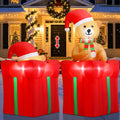 Inflatable teddy bear in a Santa hat rising from a red gift box