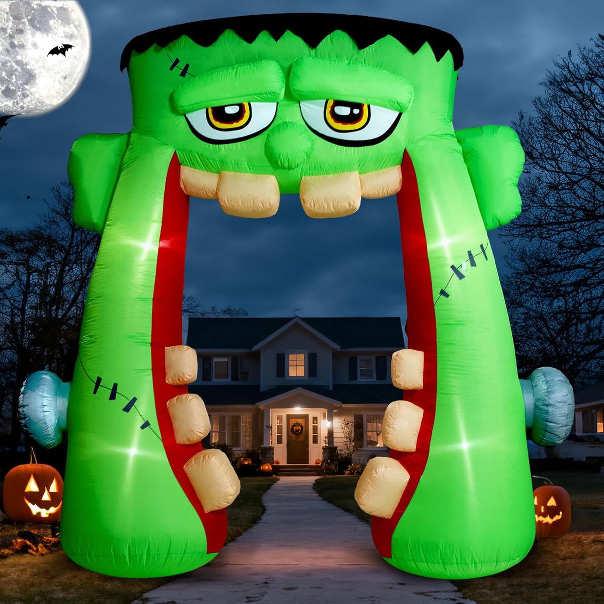 Green inflatable monster head archway with an open mouth over a front walk