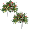 Two lighted faux pine urn fillers with red berries and pinecones