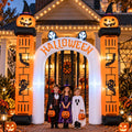 White inflatable Halloween archway with pumpkins and a reaper, children walking through